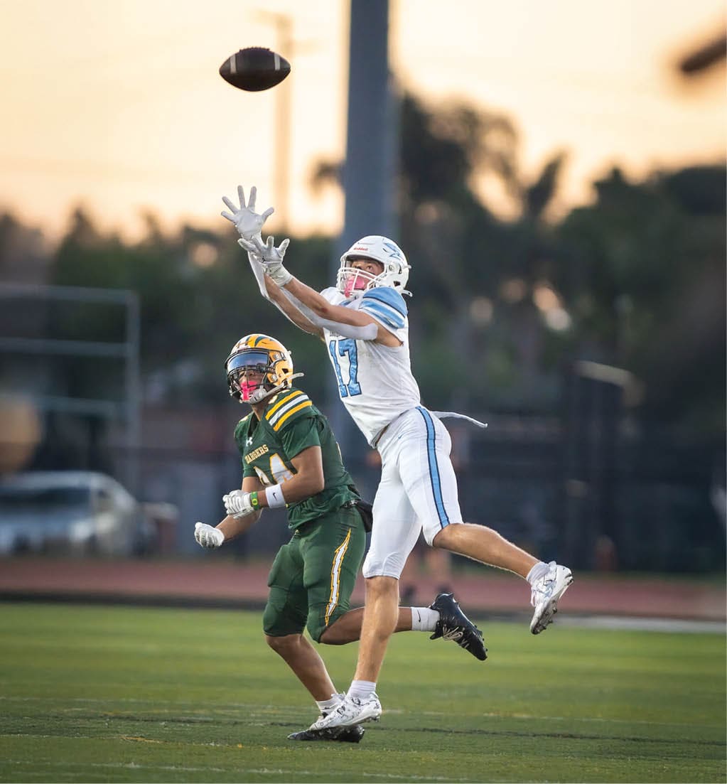 A football player running with a football. Description generated by AI