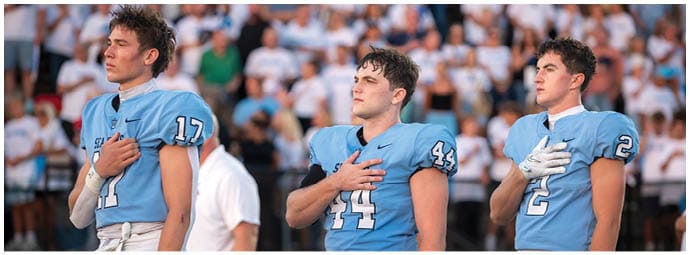 A football player wearing a blue and white uniform. Description generated by AI