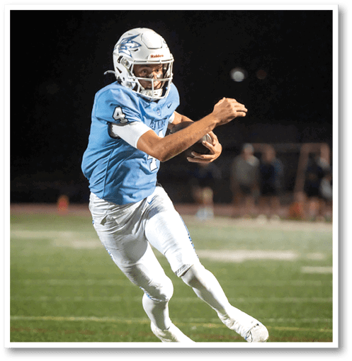 A football player wearing a black jersey with the number 6 on it. Description generated by AI