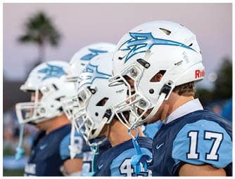 A group of football players on a field. Description generated by AI
