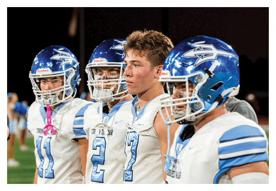 A group of football players wearing headphones and smiling. AI generated content