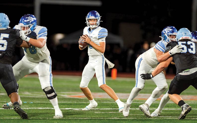 A football player wearing a blue and white jersey with the number 11 on it. Description generated by AI