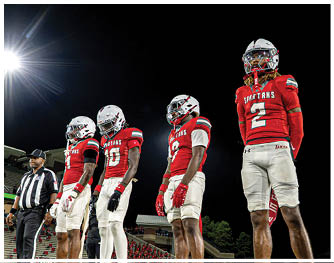 A group of football players celebrating a touchdown. Description generated by AI