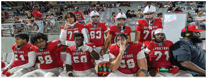 A group of football players on a field. Description generated by AI