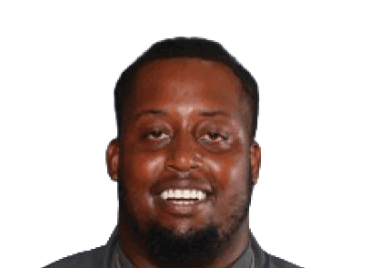 A person with short hair and a beard is smiling against a white background. Description generated by AI
