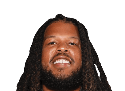 Person with long dreadlocks and a beard smiling against a white background. Description generated by AI