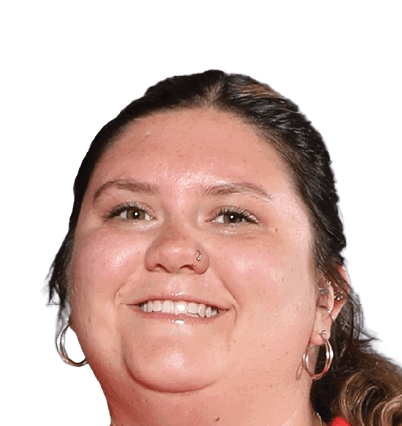 A person with long hair pulled back is smiling and wearing hoop earrings and a nose ring against a white background. Description generated by AI