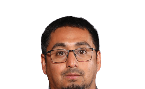 Person with short dark hair and glasses looking forward against a white background. Description generated by AI