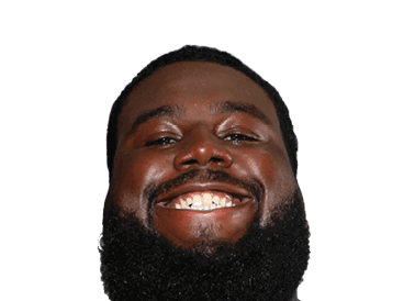 A person with short hair and a beard is smiling broadly against a white background. Description generated by AI