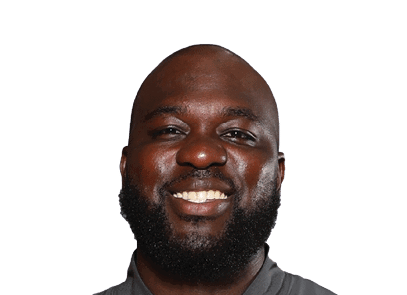 A smiling adult with a bald head and a full beard wearing a dark collared shirt. Description generated by AI