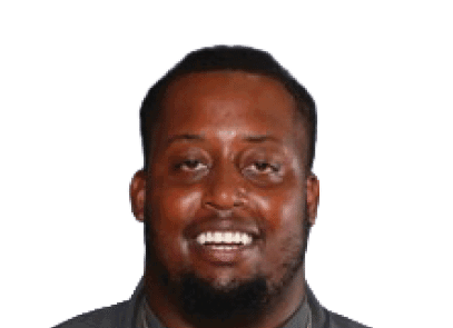 A person with short hair and a beard is smiling against a white background. Description generated by AI