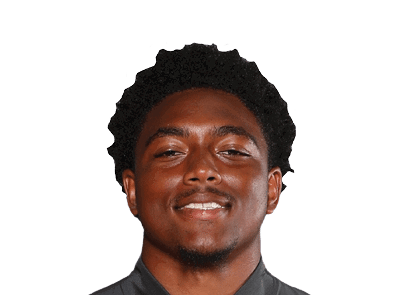 A person with short curly hair is smiling and wearing a dark collared shirt against a white background. Description generated by AI