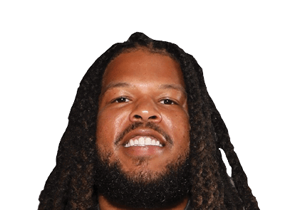 Person with long dreadlocks and a beard smiling against a white background. Description generated by AI