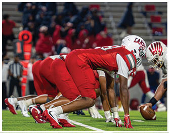 A group of football players celebrating a touchdown. Description generated by AI