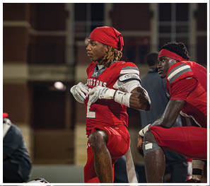 A group of football players celebrating a touchdown. Description generated by AI