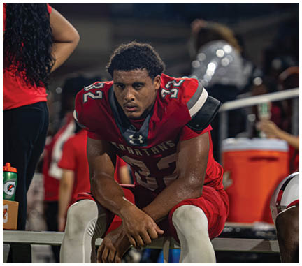 A football player wearing a blue jersey with the number 58 on it. Description generated by AI