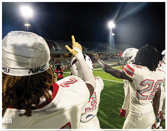 A group of football players celebrating a touchdown. Description generated by AI
