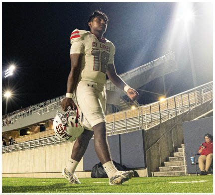 A football player running on the field. Description generated by AI