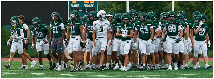A group of football players on a field. Description generated by AI