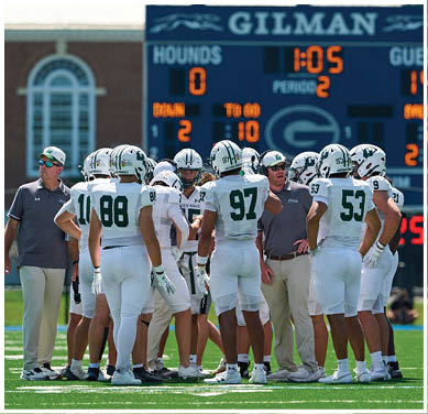 A football game is taking place with a group of men on the field. Description generated by AI
