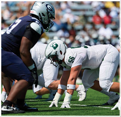 A football game is taking place with a group of men on the field. Description generated by AI