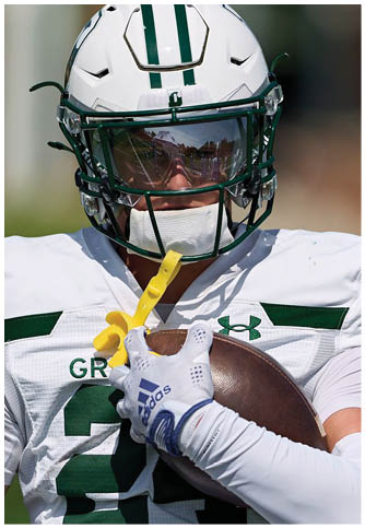 Two football players wearing blue and white uniforms. Description generated by AI