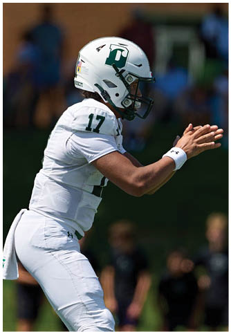 Two football players wearing blue and white uniforms. Description generated by AI