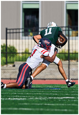 Two football players wearing blue and white uniforms. Description generated by AI