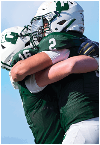 Two football players wearing blue and white uniforms. Description generated by AI