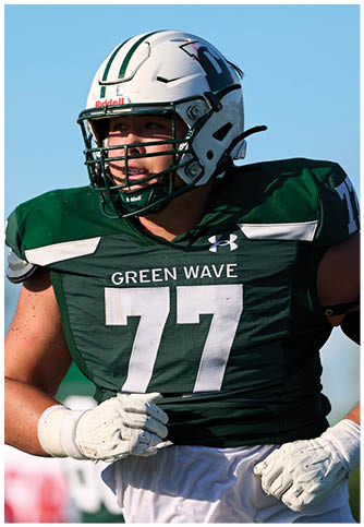 Two football players wearing blue and white uniforms. Description generated by AI