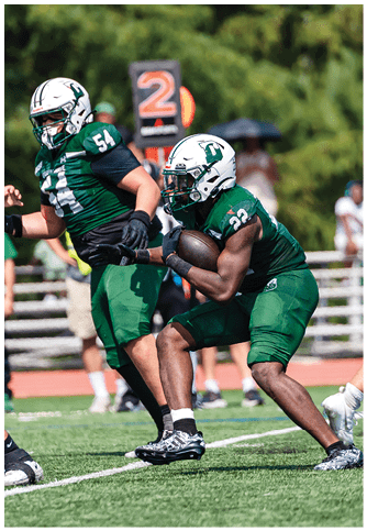 Two football players wearing blue and white uniforms. Description generated by AI