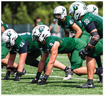 A football game is taking place with a group of men on the field. Description generated by AI