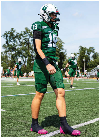 A football player wearing a blue and red jersey. Description generated by AI