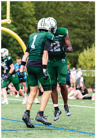 Two football players wearing blue and white uniforms. Description generated by AI