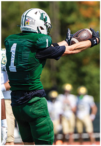 Two football players wearing blue and white uniforms. Description generated by AI