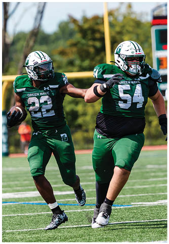 Two football players wearing blue and white uniforms. Description generated by AI