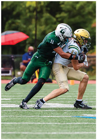 Two football players wearing blue and white uniforms. Description generated by AI