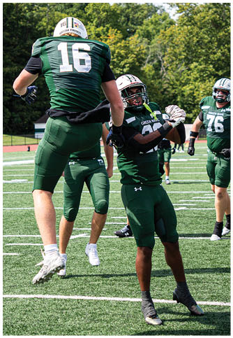 Two football players wearing blue and white uniforms. Description generated by AI