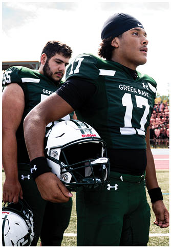 Two football players wearing blue and white uniforms. Description generated by AI