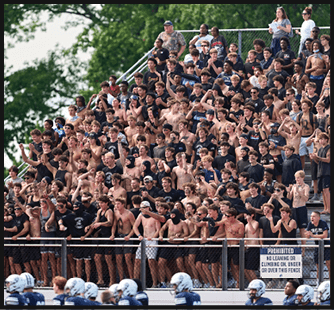 A football game is taking place with a group of men on the field. Description generated by AI