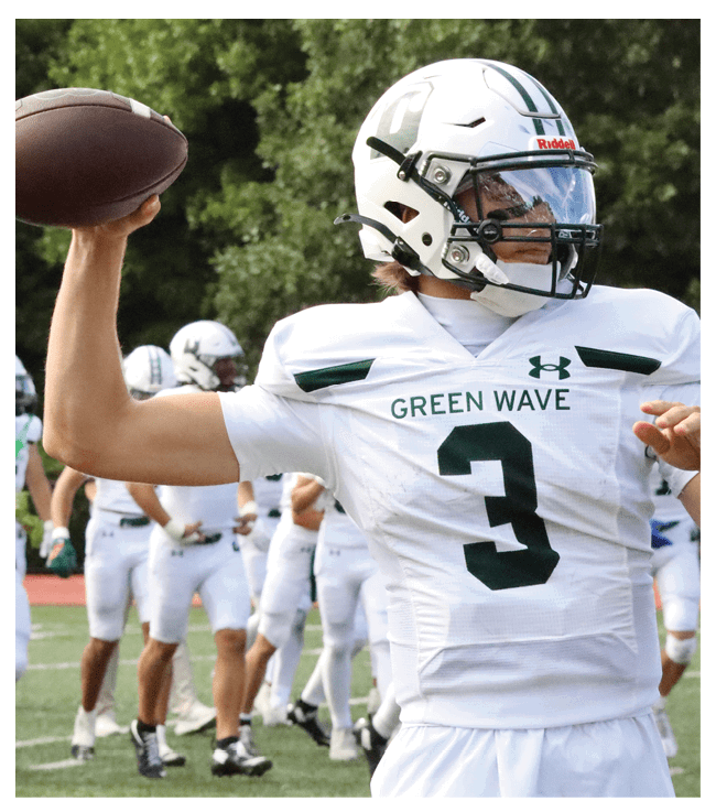 A football game is in progress with players on the field. One player is throwing a football while another player is trying to catch it. The players are wearing uniforms and are actively engaged in the game. AI generated content