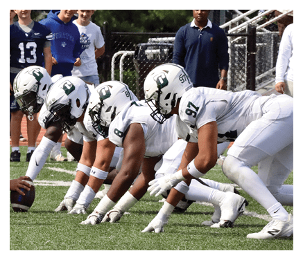 Two football players celebrating a touchdown with one player jumping in the air. AI generated content