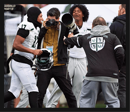 A group of young men wearing black jerseys with the word “Vista" on the front are celebrating a victory. AI generated content
