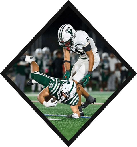 A football player wearing a black jersey with the number 10 sits on the ground with a football helmet on the ground next to him. AI generated content