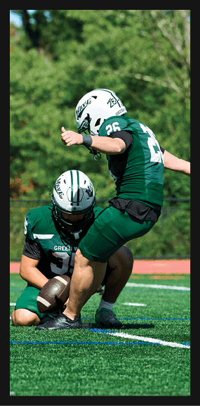 A football player is kneeling on the field, wearing a green jersey and a helmet. AI generated content