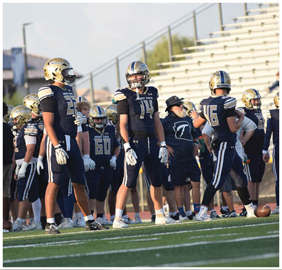 A group of football players in uniforms are standing on a field. AI generated content