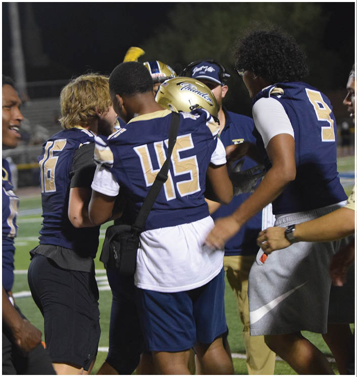 A group of football players hugging each other on the field. AI generated content