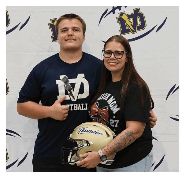 A man and woman pose with a football helmet and jersey. AI generated content
