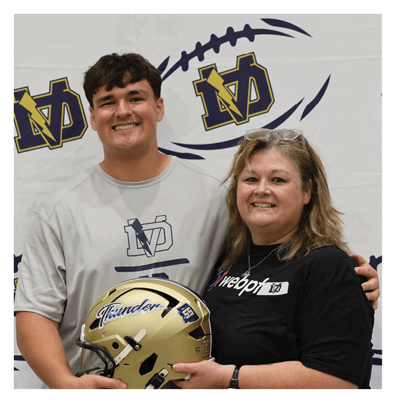A man and woman pose together with a football helmet. AI generated content
