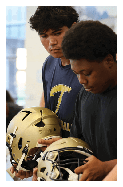 Two young men are holding football helmets in their hands. AI generated content